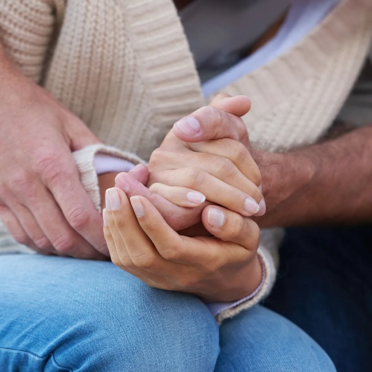Hands held together in a supportive gesture